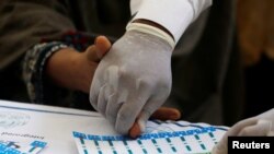 A medical worker helps a woman to draw blood for a HIV test at the free medical camp in Ratodero, Pakistan May 25, 2019. Picture taken May 25, 2019. REUTERS/Akhtar Soomro 