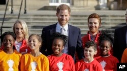 El Príncipe Enrique posa con los escolares de la Copa Mundial de la Liga de Rugby 2021 James Simpson, rn los jardines del Palacio de Buckingham en Londres, el jueves 16 de enero de 2020.