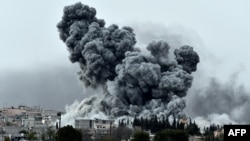 Une épaisse fumée, des débris et des flammes s’élèvent après une frappe aérienne de la coalition menée par les Etats-Unis à Kobani, en Syrie alors que des combats s’intensifient entre les Kurdes Syriens et des combattants de l’Etat Islamique, comme observé depuis les faubourgs de Suruc, à la frontière Turco-Syrienne, dimanche le 12 octobre 2014. (AP Photo/Lefteris Pitarakis)