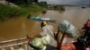FILE PHOTO - A vendor, foreground, stands on a ferry together with his goods before crossing the Mekong river in Dei Edth village at the outskirt of Phnom Penh, Cambodia, Wednesday, July 22, 2020. (AP Photo/Heng Sinith)