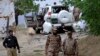 Pakistani security officials stand guard at the site of a suicide bombing which killed dozens of people and left many injured in Mastung district near Quetta, Pakistan, May 12, 2017.