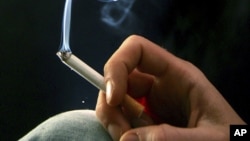 FILE - A woman smokes a cigarette. 