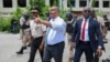 FILE - Haitian interim Prime Minister Garry Conille points as he walks with Police Chief Normil Rameau, left, in Port-au-Prince, Haiti, July 9, 2024. 