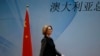 Australia's Prime Minister Julia Gillard walks past a Chinese national flag as she arrives at a welcoming lunch during the Australia China Economic and Trade Forum at a hotel in Beijing, April 9, 2013. The Chinese characters read, "Australia." 
