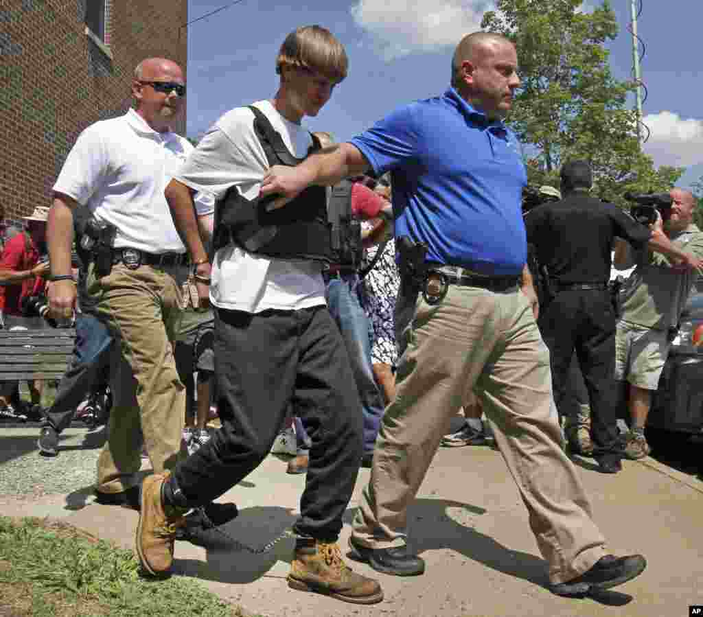 Mtuhumiwa wa Charleston,&nbsp; Dylann Storm Roof, wapili kutoka kushoto akichukuliwa na maafisa wa usalama baada ya kuwauwa waumini 9 katika kanisa la kihistoria la watu weusi, June 18, 2015.