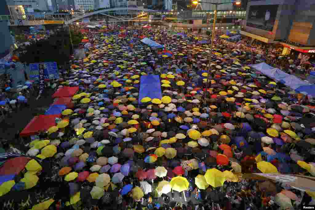 Protesters open their umbrellas, symbols of the pro-democracy movement, as they mark exactly one month since they took to the streets, in the financial district, Hong Kong, Oct. 28, 2014.