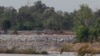 FILE - In this June 20, 2016 file photo, a fishing boat passes near a construction site of the Don Sahong dam, near Cambodia-Laos borders, in Preah Romkel village, Stung Treng province, northeast of Phnom Penh, Cambodia. The Mekong River Commission, an organization that groups together Laos, Cambodia, Vietnam and Thailand for joint management of the river, said in a statement it has received notice from Laos that it will undertake a process of consultation about the Pak Beng dam. (AP Photo/Heng Sinith, File)