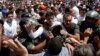 Opposition leader Leopoldo Lopez, dressed in white and holding up a flower stem, is taken into custody by Bolivarian National Guards, in Caracas, Venezuela, Feb. 18, 2014. 