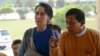 FILE - Myanmar democracy icon Aung San Suu Kyi (L) is escorted by National League for Democracy (NLD) senior leader and lawmaker Zaw Myint Maung (R) as she arrives at the parliament in Naypyidaw on March 1, 2016.