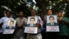 Indian journalists hold candles and photographs of Akshay Singh, who died July 4 under mysterious circumstances while reporting on corruption allegations in Madhya Pradesh, during a memorial meeting in Bangalore, India, July 6, 2015. 