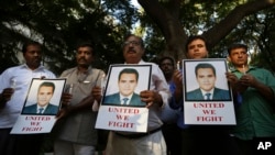 Indian journalists hold candles and photographs of Akshay Singh, who died July 4 under mysterious circumstances while reporting on corruption allegations in Madhya Pradesh, during a memorial meeting in Bangalore, India, July 6, 2015. 