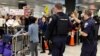 Police direct arriving passengers past dozens of pro-immigration demonstrators who cheer and hold signs at Dulles International Airport, to protest President Donald Trump's travel ban in Chantilly, Virginia, in suburban Washington, Jan. 29, 2017.