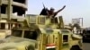 FILE - This image taken from video shows an Islamic State militant waving upon his arrival in Beiji, north of Baghdad, June 17, 2014.