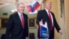 Small Russian flags bearing the word "Trump" are thrown by a protester toward President Donald Trump, as he walks with Senate Majority Leader Mitch McConnell, R-Ky., on Capitol Hill to have lunch with Senate Republicans.