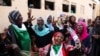 FILE - Sudanese pro-democracy supporters celebrate a final power-sharing agreement with the ruling military council, in Khartoum, Aug. 17, 2019. For the first time in three decades, Sudan has charted a path out of military rule.