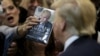 FILE - A woman thrusts Republican Donald Trump's book at him for an autograph at his campaign rally in Manassas, Virginia, Dec. 2, 2015. Trump said at the time that his plan for combating Islamic State militants involved targeting not just the group's fighters but also their families.