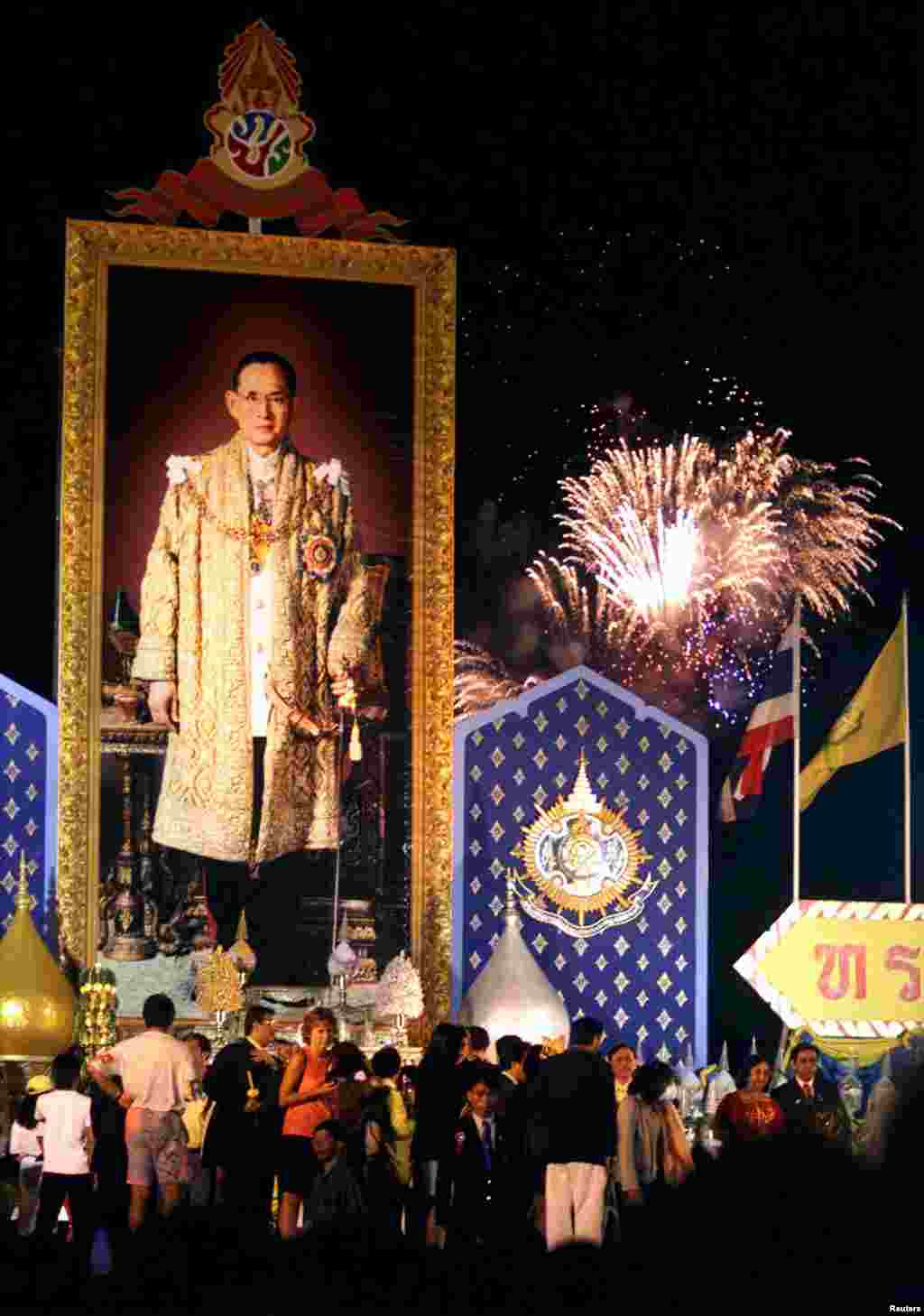 រូបព្រះមហាក្សត្រ​ថៃ​ព្រះបាទ Bhumidol Adulyadej (ខាង​ឆ្វេង) ដាក់​នៅ​លើ​ឆាក​មួយ ស្របពេល​មាន​ការ​បាញ់កាំជ្រួច​ នៅ​ក្រុង​បាងកក កាល​ពី​ថ្ងៃ​ទី០៥ ខែ​ធ្នូ ឆ្នាំ​១៩៩៩ ក្នុង​ការ​អបអរសាទរ​ពិធី​បុណ្យ​ចម្រើន​ព្រះជន្ម ៧២ ព្រះវស្សា។&nbsp;