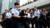 A demonstrator is taken away by policewomen from an area previously blocked by pro-democracy supporters, outside the government headquarters in Hong Kong, December 11, 2014.