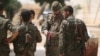 A U.S. fighter, who is fighting alongside Syria Democratic Forces (SDF), carries his national flag as he stands with SDF fighters in the northern province of Raqqa, Syria, May 27, 2016.