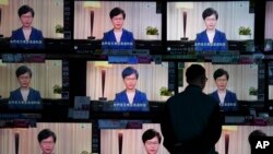A man watches the television message that Hong Kong Chief Executive Carrie Lam makes an announcement on the extradition bill, at a home electronics retailer in Hong Kong, on Wednesday, Sept. 4, 2019. Chief Executive Lam has announced the government…