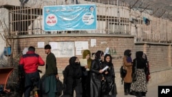 Wanafunzi wanawake wa Afghanistan wakisimama nje ya Chuo kikuu cha mjini Kabul, Disemba 21, 2022. Picha ya AP