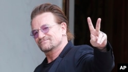 រូបឯកសារ៖ តា​រា​ចម្រៀង​ Bono លើក​សញ្ញា​សន្តិភាព​នៅ​ពេល​លោក​មក​ដល់​ការ​ប្រជុំ​មួយ​នៅ​វិមាន​ Elysee ក្នុង​ទីក្រុង​ប៉ារីស ប្រទេស​បារាំង កាល​ពី​ខែ​កក្កដា។