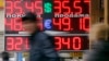 FILE - People pass by a board displaying exchange currency rates in Moscow, April 3, 2014.