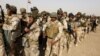 Iraqi security forces wait for vehicles traveling to Mosul to fight against militants of Islamic State at an Iraqi army base in Camp Taji in Baghdad, Feb. 21, 2016.