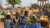 FILE - Children wait for their turn to buy water from a privately-owned water tower, amid an outbreak of the coronavirus disease, in Taabtenga district of Ouagadougou, Burkina Faso, April 3, 2020.