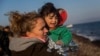 A volunteer holds a baby after her family's arrival on a dinghy from the Turkish coast to the northeastern Greek island of Lesbos on Nov. 17, 2015.