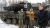 Lithuanian Minister of National Defense Arvydas Anusauskas, left, attends the testing of a Leopard 2 tank at a military training area in Rukla, Lithuania, on Dec. 15, 2023.