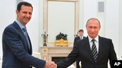 ប្រធានាធិបតី​ស៊ីរី​លោក Bashar Al-Assad (ខាងឆ្វេង) ចាប់​ដៃ​ជាមួយ​ប្រធានាធិបតី​ស៊ីរី​លោក Vladmir Putin ។