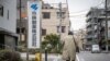 Seorang pria berjalan melewati papan nama Kobayashi Pharmaceutical di luar kantor perusahaan farmasi itu di Tokyo, 28 Maret 2024. (Foto: Yuichi Yamazaki/AFP)