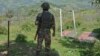 FILE- Indian army soldier guards near fence on the line of control near Balakot sector in Poonch, Jammu and Kashmir, India, Aug.17, 2015. 