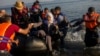 Migrants from Syria and Afghanistan arrive on an overcrowded dinghy from the Turkish coasts to the Greek island of Lesbos, Monday, July 27, 2015. 