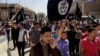 FILE - Demonstrators chant pro-Islamic State group slogans as they carry the group's flags in front of the provincial government headquarters in Mosul, Iraq, June 16, 2014.