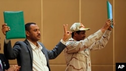 Jenerali Mohamed Hamdan Daglo, Naibu mkuu wa baraza la kijeshi, kulia, na kiongozi wa waandamanaji nchini Sudan Ahmed Rabie baada ya kutia saini mkataba wa kihistoria wa makubaliano mjini Khartoum, Sudan, Agosti 4, 2019.