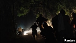 Familia za wakimbizi kutoka Mexico wakijisalimisha kwa walinzi wa mpakani wa Marekani. 