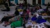 Voters gather and rest on the floor at the end of the voting day in a polling station at the Reverend Kim School in Kinshasa, Congo, on Dec. 20, 2023.