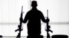 FILE - An agent of the U.S. Bureau of Alcohol, Tobacco, Firearms and Explosives holds guns at an ATF field office in Glendale, California, Aug. 9, 2017.