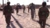 FILE - This frame grab from video released Aug. 11, 2017, and provided by Furat FM, a Syrian Kurdish activist-run media group, shows U.S.-backed Syrian Democratic Forces (SDF) fighters advance in Raqqa, Syria. 