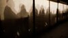 Migrants are silhouetted as they warm themselves inside a waiting tent to get an appointment at the central registration center for refugees and asylum seekers LaGeSo (Landesamt fuer Gesundheit und Soziales - State Office for Health and Social Affairs) in Berlin, Jan. 6, 2016. 