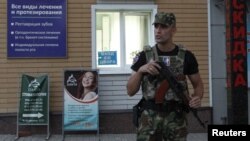 An armed serviceman stands guard at a cordon near a cafe, where leader of the separatist self-proclaimed Donetsk People's Republic Alexander Zakharchenko was killed, in Donetsk, Ukraine, Aug. 31, 2018.