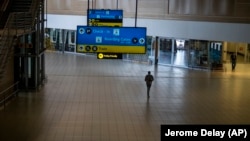 Mtu mmoja akitembea katika uwanja wa ndege wa OR Tambo Johannesburg ambao hauna mtu wakati nchi zikifunga usafiri kutoka na kitisho cha kirusi cha omicron.
