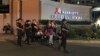 Armed security officers and onlookers gather outside a hotel at the Resorts World Manila complex, early Friday, June 2, 2017, in Manila, Philippines. 