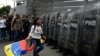 FILE - Opposition supporters confront Venezuelan security forces at the National Assembly in Caracas, Venezuela, March 10, 2020. 