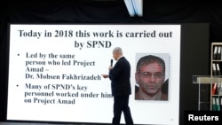 Waziri Mkuu wa Israeli, Benjamin Netanyahu atembea mbele ya bango lenye picha ya mwanasayansi wa masuala ya nyuklia wa Iran Mohsen Fakh-rizade. Aprili 30, 2018. 