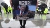 FILE - A protester holds a banner showing an image of U.S. President Donald Trump during a rally to oppose the United States' policies against North Korea near U.S. Embassy in Seoul, South Korea, Oct. 7, 2019. 