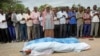 FILE - Mourners pray over the bodies of journalists Mohamed Abdikarim Moallim Adam, a reporter for the London-based Universal television, and Abdihakin Mohamed Omar, a producer for the Somali Broadcasting Corporation, at their funeral in Mogadishu, Somalia, July 27, 2015. 