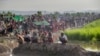 Newly arrived Rohingya Muslims who crossed over from Myanmar into Bangladesh rest in a field. After spending a night in the open, they wait for permission to proceed to refugee camps, Palong Khali, Bangladesh, Oct. 17, 2017. 